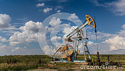 Operating oil and gas well profiled on cloudy sky Stock Photo