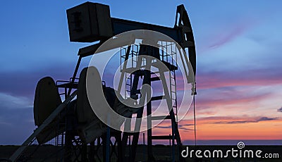 Operating oil and gas well profiled on sunset sky Stock Photo
