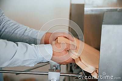 Operating printing cutting machine. Print house worker in white clothes is indoors Stock Photo