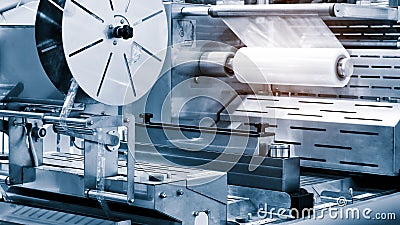 The operation of automatic plastic bag production machine with lighting effect. Close-up of the roller of the plastic bag producti Stock Photo