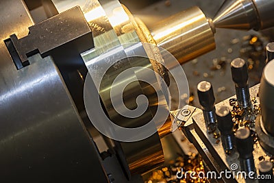 The operation of lathe machine cutting the brass shaft material. Stock Photo