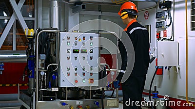 Operator adjusts parameters on control panel to ensure stable operation of industrial equipment, helping to avoid Stock Photo