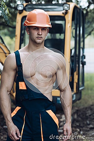 Operator concept. Excavator operator on construction site. Muscular operator in working uniform. Machine operator with Stock Photo