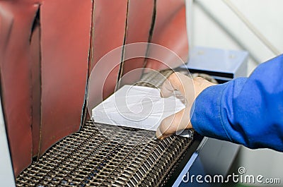 Operator hand place Book on Print plant roller conveyor Stock Photo