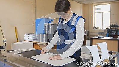 The operator of the printing house works at the typographical machine Stock Photo