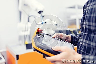 Operator uses radio remote to control robot arm with automatic hand Stock Photo