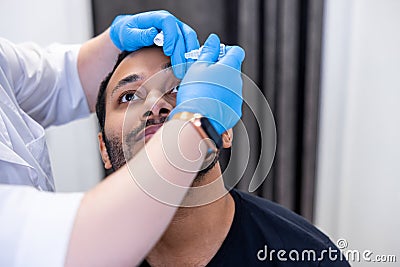 Ophtalmologist dropping eye drops to patients eyes Stock Photo