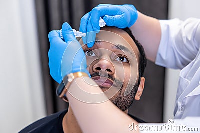 Ophtalmologist dropping eye drops to patients eyes Stock Photo