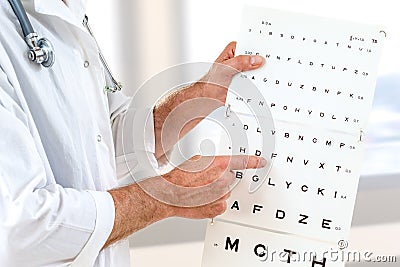 Ophthalmologist checking patient eyesight, pointing letters, eyes examination at office Stock Photo