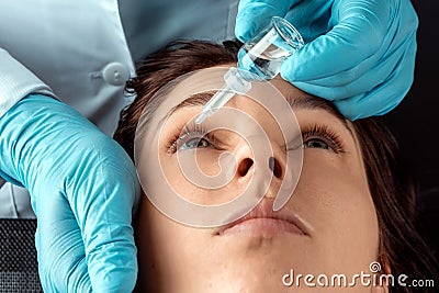 An ophthalmologist injects drops into the eyes of patients in an ophthalmic clinic. Health, vision, eye disease Stock Photo