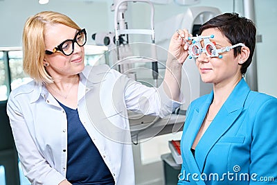 Ophthalmologist performing monocular subjective refraction test in adult woman Stock Photo