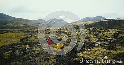 Opinión aérea el grupo de turistas que caminan en campos de lava en Islandia Fotógrafo de la mujer que sostiene la cámara, amigos almacen de video Opinión aérea el grupo de turistas que caminan en campos de lava en Islandia Fotógrafo de la mujer que sostiene la cámara, amigos almacen de video