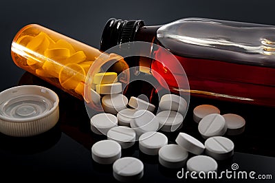 Opioid epidemic, drug abuse and dangerous mixing of barbiturates and alcohol concept with oxycodone pills fallen out of a Stock Photo