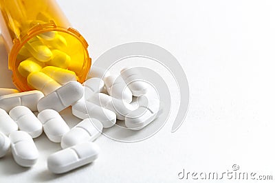 Opioid epidemic, drug abuse and overdose concept with scattered prescription opioids spilling from orange bottle with copy space. Stock Photo