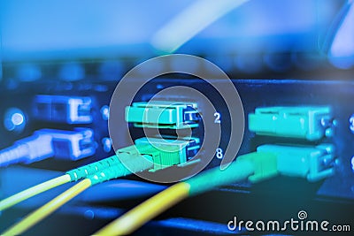 Optical cable in internet network devices. Green and yellow optical fiber cable in switch Stock Photo