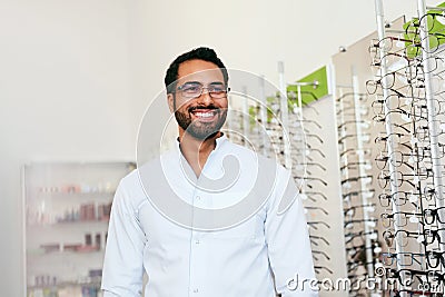 Optician Man Near Showcase With Eyeglasses At Glasses Shop Stock Photo