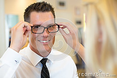 Optician or optometrist consulting a customer about eyeglasses Stock Photo