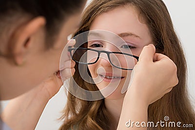 Optician Putting Eyeglasses On A Patient Stock Photo