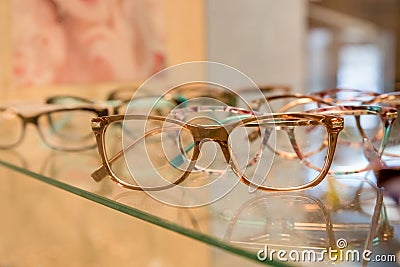 Optics, health care and vision concept - close up of eyeglasses at optician.exhibitor of glasses consisting of shelves Stock Photo