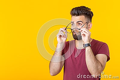 Optics, vision and style concept - Take off put on glasses. Close up portrait of surprised man touching rim-glasses on Stock Photo