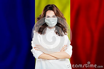 Optimistic doctor in face mask against national flag Romania. Flu epidemic and virus protection concept Stock Photo