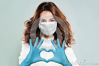 Optimistic doctor woman in protective mask making heart. Help, support, healthy lifestyle, healthcare, medicine and ambulance Stock Photo