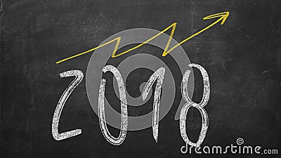 Optimistic year graph drawn on the blackboard. handwritten 2018 year inscription with growing yellow arrow Stock Photo