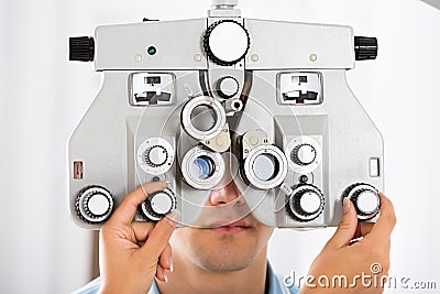 An Optometrist Adjusting Phoropter For Patient Stock Photo