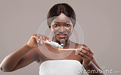 Oral Hygiene. Beautiful Black Woman Applying Toothpaste On Eco Bamboo Toothbrush Stock Photo