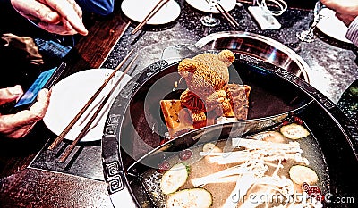 Orande melting piece of fat shaped as bear figure in steel hot d Stock Photo