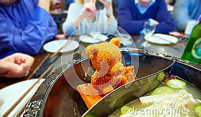 Orande melting piece of fat shaped as bear figure in steel hot dish for cooking of traditional Chinese food Stock Photo