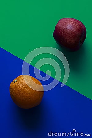 Orange and apple on blue and green background, minimalist photography Stock Photo