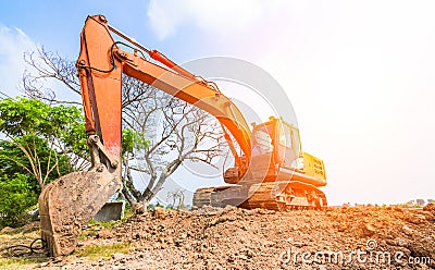 The orange backhoe is on the ground. Stock Photo