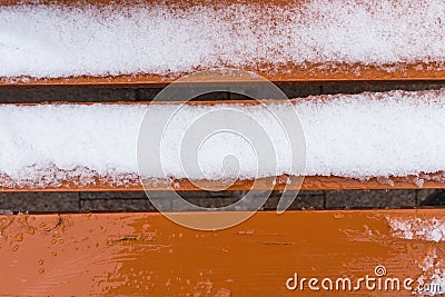 Orange bench covered in snow Stock Photo