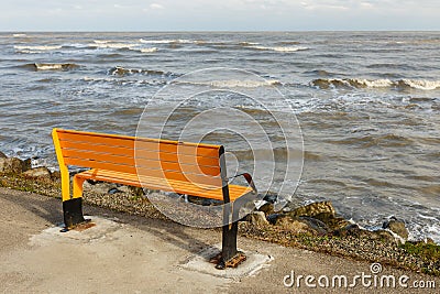 Orange bench on the rocky shore of the Caspian Sea, Astara, Iran Stock Photo