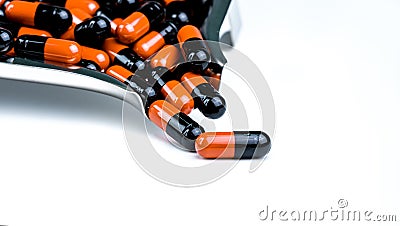 Orange-black capsule pills on drug tray. Antibiotics drug resistance. Drug use with reasonable. Antimicrobial capsule pills. Stock Photo