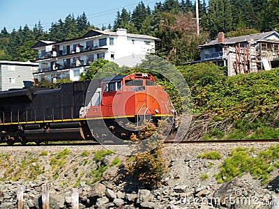 Orange and Black Train Engine Going Down Tracks Stock Photo