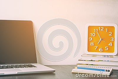 Orange Clock on office table laptop Stock Photo