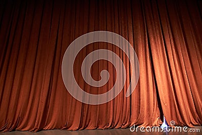 Orange closed curtain or drapes in theater with copy space. Theatrical performance concept. Spot of light on the curtain Stock Photo