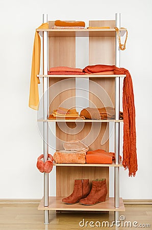 Orange clothes nicely arranged on a shelf. Stock Photo