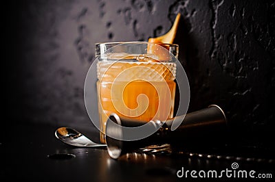 Orange cocktail in crystal glass with bar spoon and jigger Stock Photo