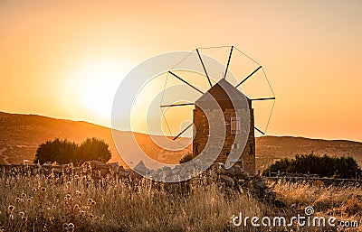 Orange colours of sunset time, one old windmill in the mountains Stock Photo