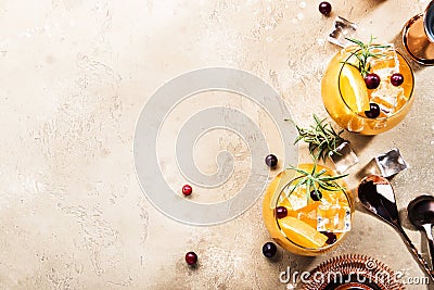 Orange Cranberry Rosemary and Vodka cocktail, copper bar tools, beige background, hard light, top view Stock Photo