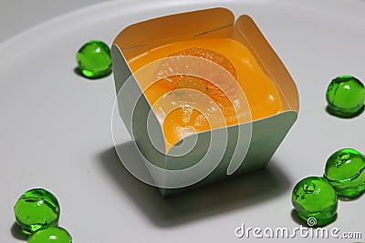 Orange cupcake and topping with orange sacs and jelly green round. Stock Photo