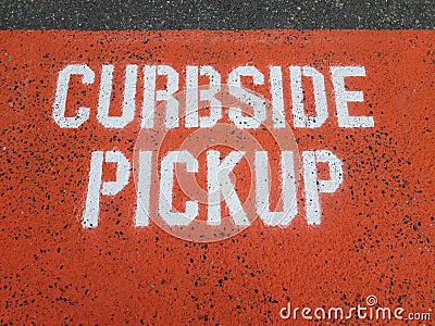 orange curbside pickup sign on asphalt or ground Stock Photo