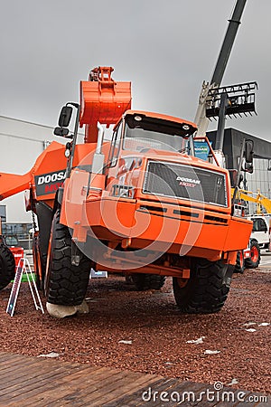 Orange diesel excavator and lorry Editorial Stock Photo