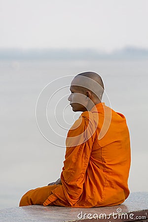 Orange dressed Cambodian monk looking at the Mekong, Phnom Penh Editorial Stock Photo