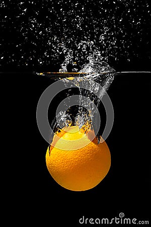 Orange drowns in water on a black background. Citrus with water splashes Stock Photo