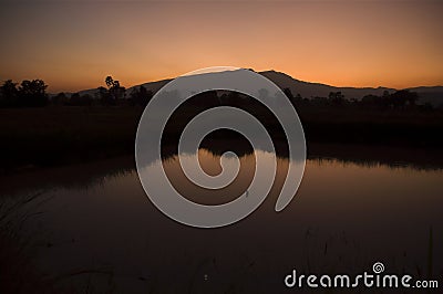 Orange dusk Mountains reflected in lake Stock Photo