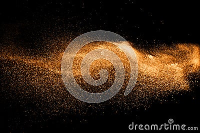 Orange dust particles explosion on black background. Stock Photo